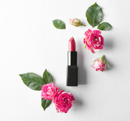 Obraz na płótnie Canvas Lipstick with beautiful flowers on white background