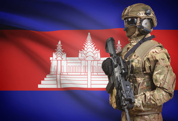 Soldier in helmet holding machine gun with flag on background series - Cambodia