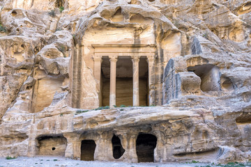 The triclinium at Little Petra, Jordan. Little Petra is an archaeological site located north of Petra. Like Petra, it is a Nabataean site, with buildings carved into the walls of the sandstone canyons
