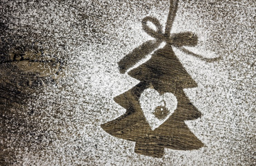 Abbild eines Weihnachtsbaums auf verschneitem Holzuntergrund