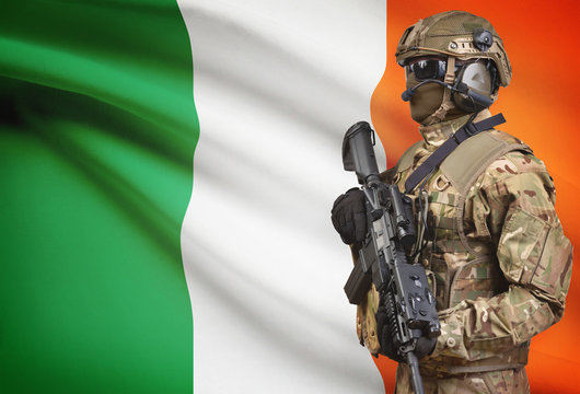 Soldier in helmet holding machine gun with flag on background series - Ireland