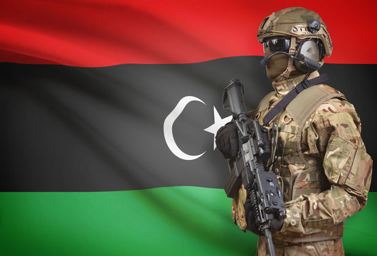 Soldier in helmet holding machine gun with flag on background series - Libya