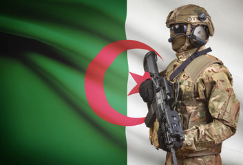 Soldier in helmet holding machine gun with flag on background series - Algeria