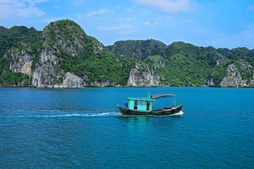 Fishing boat in Halong Bay, Vietnam, Southeast Asia. UNESCO World Heritage Site. Beautiful scenery with sea and mountain at Ha Long Bay, Vietnam. Most popular landmark, tourist destination of Vietnam.