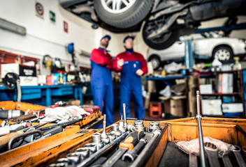 Two mechanics working on a car