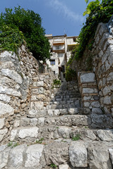 Fototapeta na wymiar Passage et escalier en pierre de style moyen-âgeux dans le village de Saint-Paul de Vence dans les Alpes-Maritimes, France