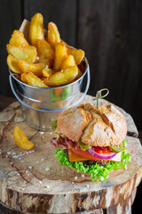 Delicious chips and burger with beef, cheese and vegetables
