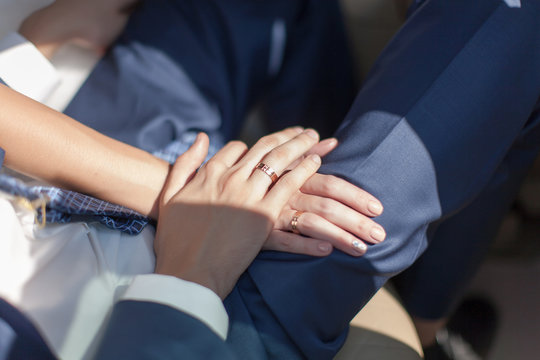 Hand of groom on hand of bride
