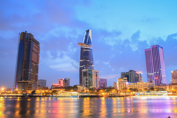 Plakat Night view of Downtown center of Ho Chi Minh city on Saigon riverbank in twilight, Vietnam. 