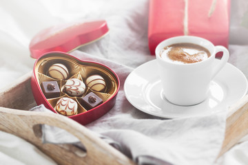 Obraz na płótnie Canvas Romantic breakfast with coffee, chocolate pralines, gift box and
