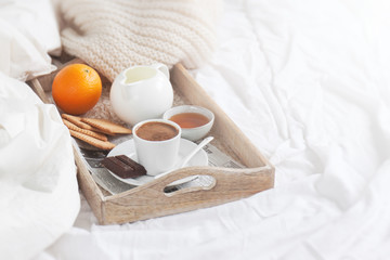 Fototapeta na wymiar Romantic breakfast on bed with coffee, cookies, orange and choco