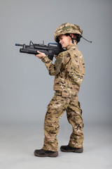 Young boy dressed like a soldier with rifle