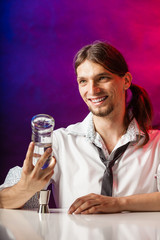 Barman fills shot glass.