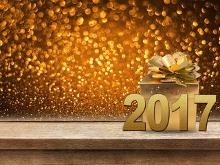 Gold gift box and ribbon with word 2017 on wood table, bokeh bac