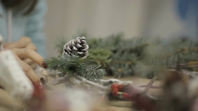 girl in the studio preparing decorations for Christmas wreaths