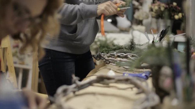 girl in the studio preparing decorations for Christmas wreaths