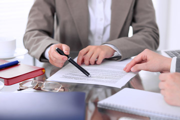 Group of business people and lawyers discussing contract papers sitting at the table, close up