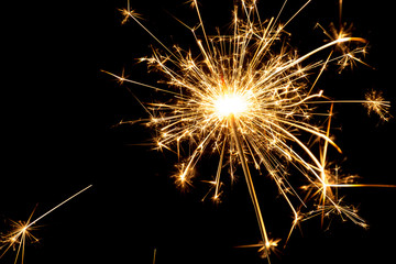 Burning sparkler at black background
