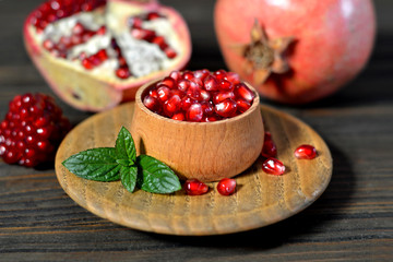Pomegranate seeds in a bowl on wooden table