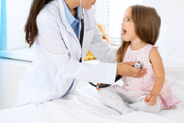 Obraz premium Doctor examining a little girl by stethoscope