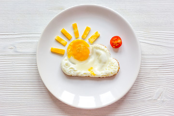 sunshine fried eggs breakfast for kid on wooden background