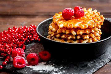 waffles with raspberries on wooden background
