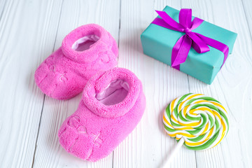 baby's bootees and gift box on wooden background