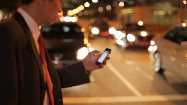 MH TS Businessman Crossing Street While Texting on Phone at Night / Singapore