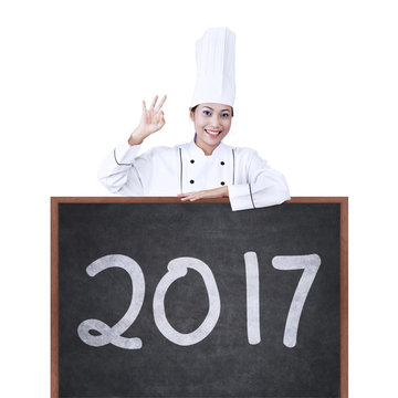 Female chef showing number 2017 on board