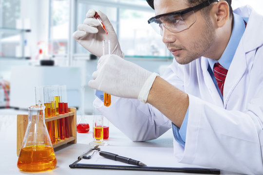 Male pharmacist doing experiment in lab