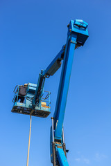 Electrical technician repairing street light by boom lift in industrial 