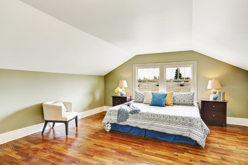 Spacious upstairs bedroom with vaulted ceiling and hardwood floor