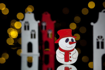 new year postcard with toy houses and snowman;