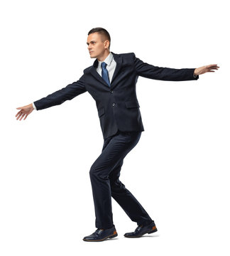 Fully concentrated businessman walking tightrope or border, isolated on white background.