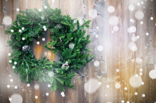 Christmas fir wreath on wooden background. Toned image. Copy space