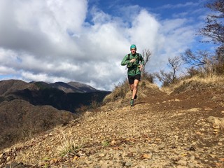 Trail runner running on mountain summit ridge path