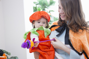 ハロウィンの飾りつけをした部屋の親子