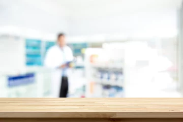 Fotobehang Empty wood counter top on blur pharmacy  background © Atstock Productions