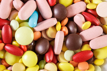 Colorful medical pills and capsules as background, health care concept