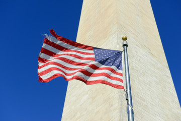 Washington Monument with waving American Flag in foreground, Washington DC, USA