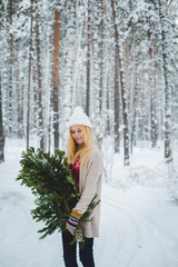 girl in winter forest holds branches in his hands