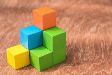 Obraz premium stack of colorful wood cube building blocks on wood background