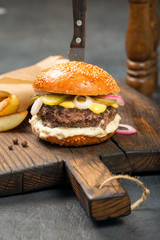 Beef fresh burger with fries on the old board