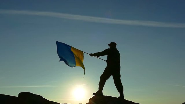Soldier silhouette, sun and Ukrainian Flag in Slow Motion 