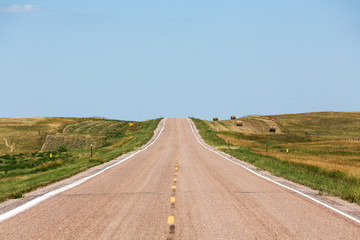 A road cutting through northern Nebraska on a summer day. 