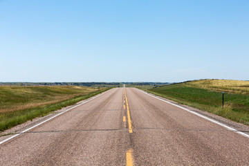 A road cutting through northern Nebraska on a summer day. 