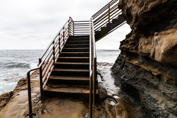 Sunset Cliffs in San Diego, California ocean access staircase for surfers on a stormy day.