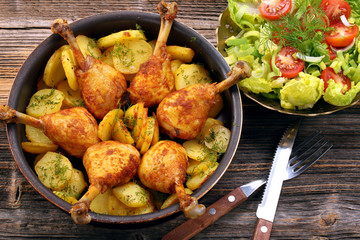 Chicken legs and baked dill potatoes with vegetable salad