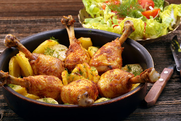 Chicken legs and baked dill potatoes with vegetable salad