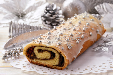 Christmas poppy seed roll on festive table.
